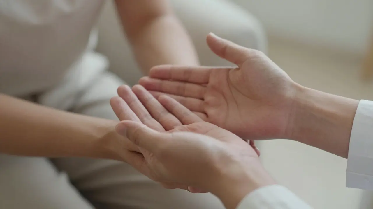 Detail rukou terapeuta a klienta symbolizující respekt k hranicím a bezpečí.